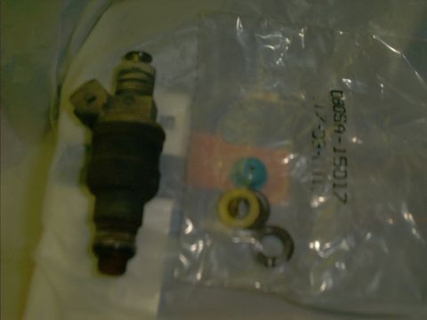 1990 Ford Bronco - A fuel injector and its associated seals are shown, with part numbers visible on the packaging.