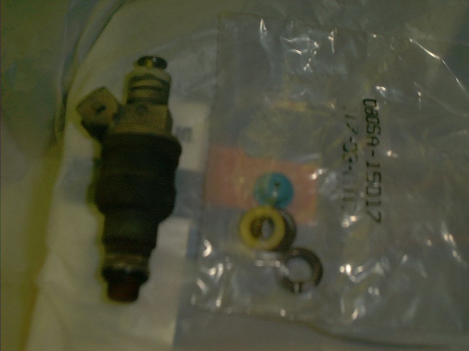 Fuel injector with blue and yellow seals next to it. Text on bag reads 08059-15017