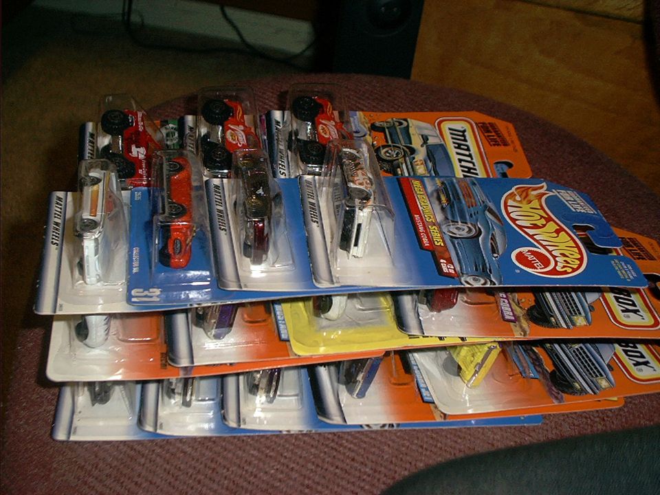 Stack of blister-packed toy cars, including Hot Wheels and Matchbox brands