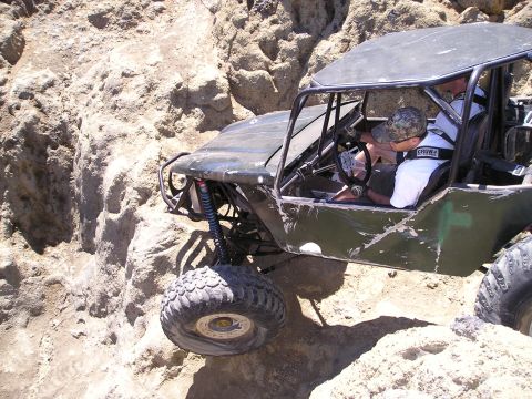 1989 Ford Bronco - Custom off-road buggy tackles challenging rocky terrain with a driver at the wheel.