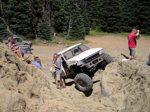 1989 Ford Bronco - Off-road enthusiasts tackle challenging rocky terrain with modified SUVs.
