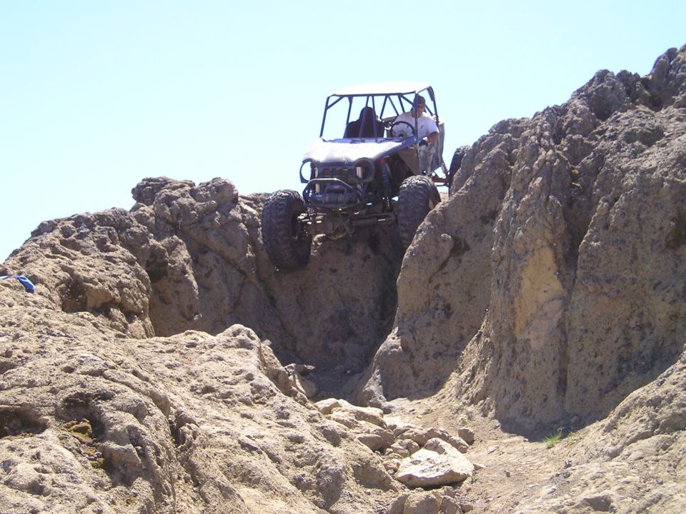 Buggy driving over rocky terrain with a person inside