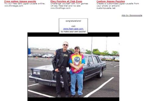 2000 Ford Crown Victoria - Two people pose with a dark sedan in a parking lot.