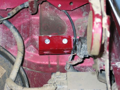 1995 Ford Bronco - Close-up view of engine bay components, including a red bracket and wiring harness on a 1995 Ford Bronco.