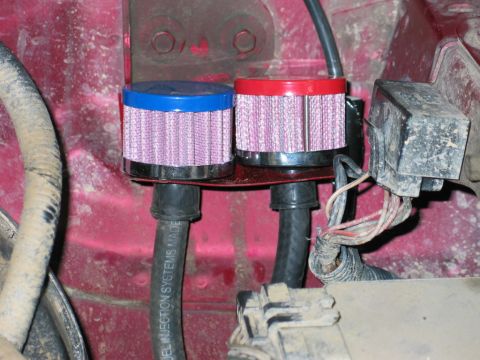 1995 Ford Bronco - Dual breather filters with blue and red caps are installed on a red bracket, connected to hoses labeled 'FUEL INJECTION SYSTEMS MADE'.