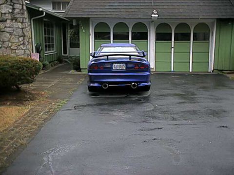 1993 Ford Probe - Rear view of a blue 1993 Ford Mustang Cobra with a spoiler and dual exhaust pipes.
