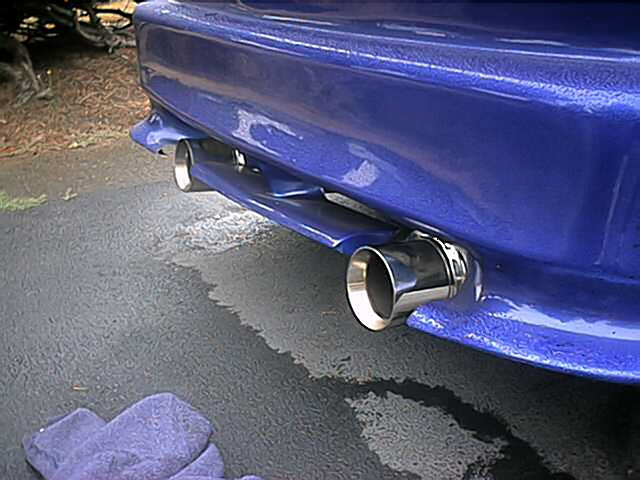 Blue car rear bumper with dual chrome exhaust tips visible