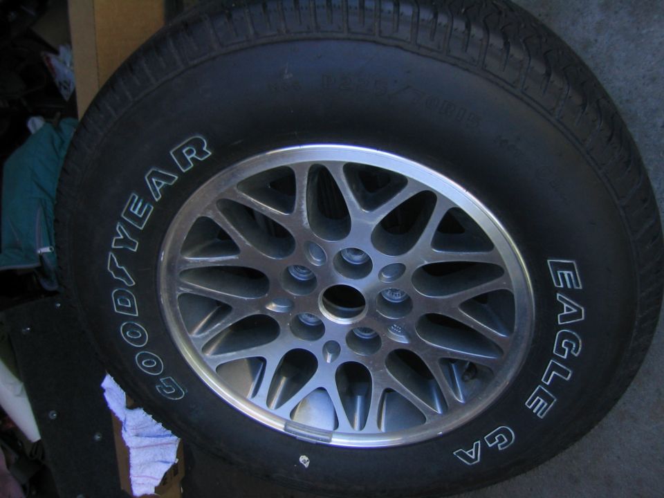 Goodyear Eagle GA tire on a multi-spoke alloy wheel lying on concrete floor
