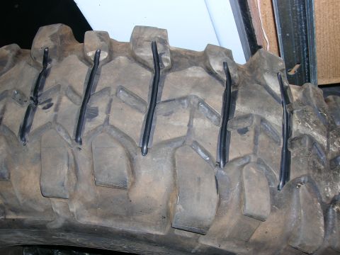 2003 Jeep TJ - This is a close-up view of a heavily treaded off-road tire with metal studs added for extra traction.