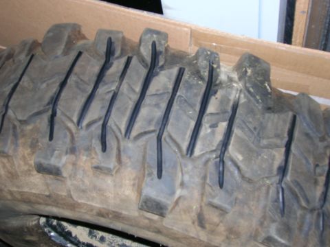 2003 Jeep TJ - Close-up of a worn tire tread with aggressive lug pattern.