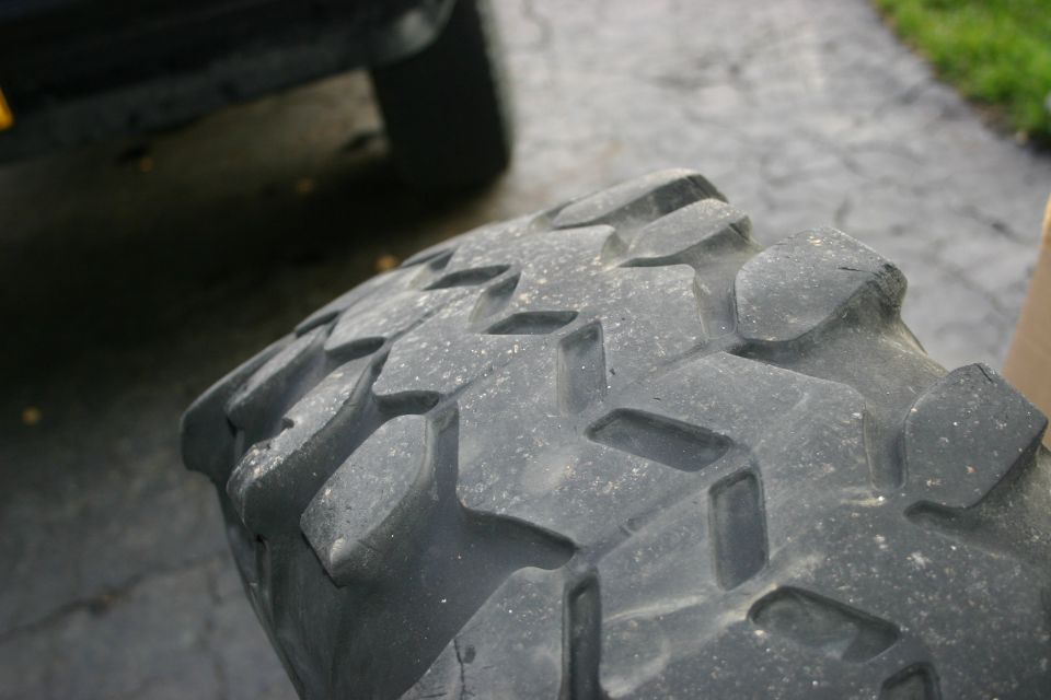 Tire tread with large, blocky lugs and deep sipes, angled view
