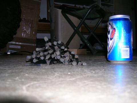 2003 Jeep TJ - A collection of zip ties sits beside a beverage can on a worn concrete surface, with various items in the background.