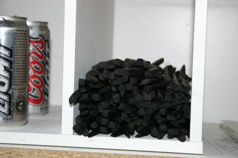 2003 Jeep TJ - Coors Light cans and a pile of charcoal sticks are stored on a white shelf.