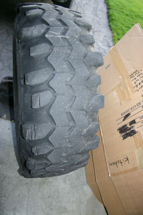 2003 Jeep TJ - A close-up view of a worn off-road tire, with a cardboard box visible to the right.