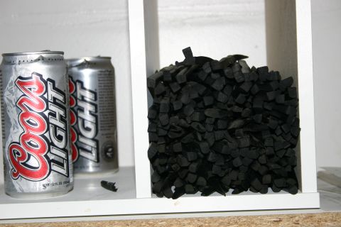 2003 Jeep TJ - A close-up view of two Coors Light beer cans and a pile of black, chopped rubber pieces.