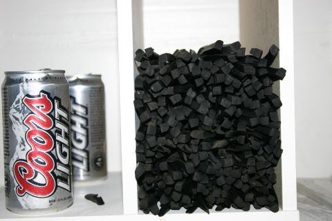 2003 Jeep TJ - Two Coors Light cans sit beside a container filled with black charcoal pieces.
