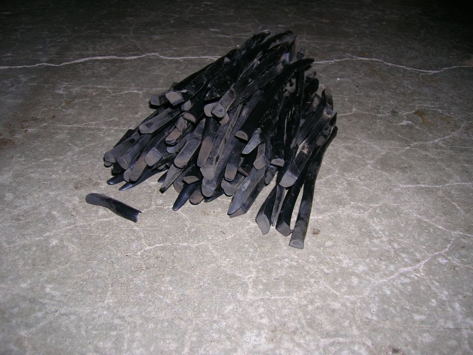 Pile of black tire levers on a concrete floor, with one broken piece separate