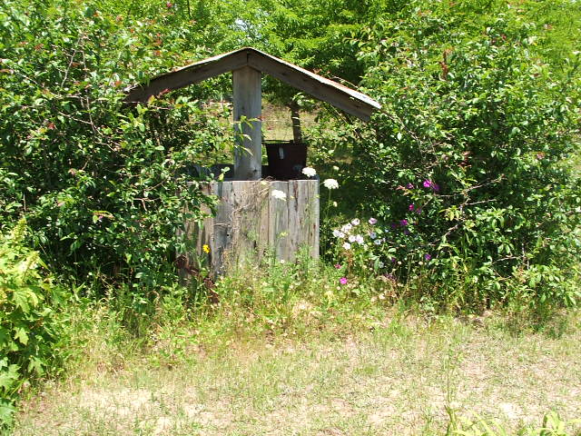 Wooden structure with a roof in a yard setting