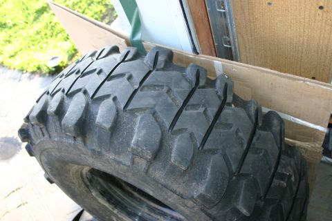 2003 Jeep TJ - A single off-road tire is shown, resting against some cardboard boxes.