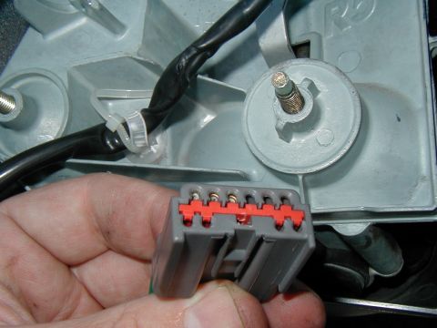 2002 Ford Excursion - Close-up of a gray electrical connector with a red locking tab and attached wiring harness.