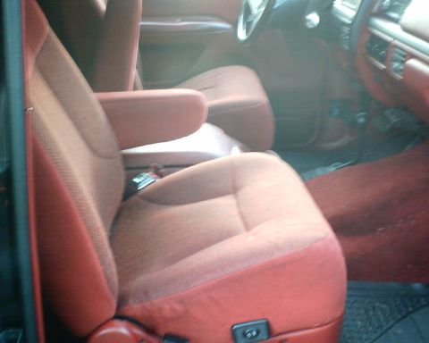 1989 Ford Bronco - The interior of the vehicle shows red fabric seats and carpeting, with a view of the dashboard and steering wheel.