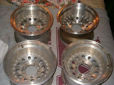 1995 Ford Bronco - Four aluminum alloy wheels are shown, possibly for a truck or SUV, resting on a patterned surface.