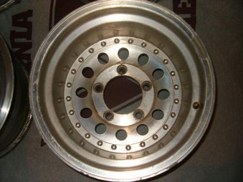 1995 Ford Bronco - Close-up of an aluminum wheel, likely a replacement part, with a multi-hole design and polished rim.