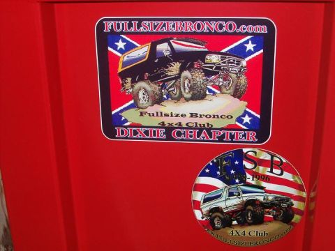 1995 Ford Bronco - Two stickers on a red surface display Ford Broncos, one with '1996' visible, contradicting the 1995 claim.