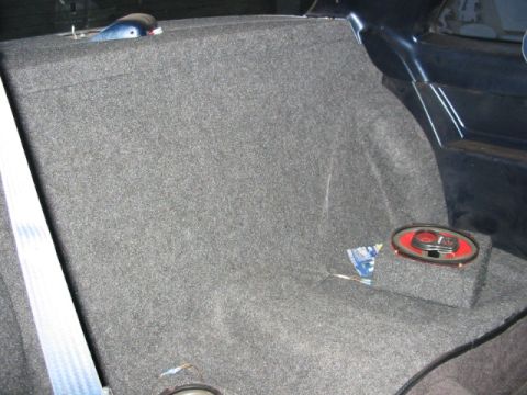 1987 Ford Thunderbird - Aftermarket speaker installation in a car's rear interior, likely a trunk or back seat area.