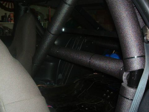 1995 Ford Probe - The interior of a vehicle shows a roll cage structure and seating.