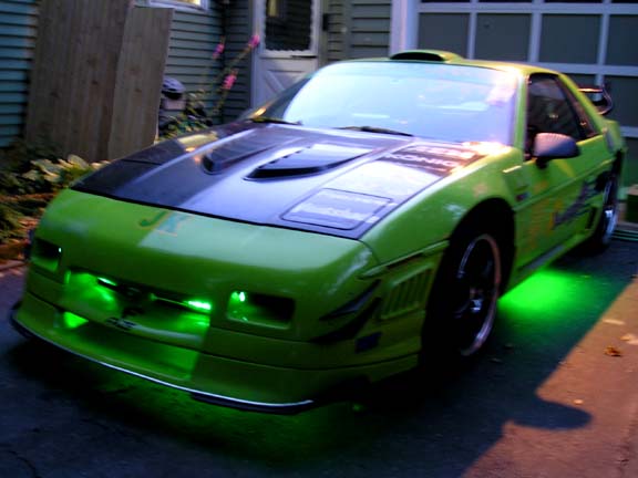 Lime green Pontiac Fiero with black hood and green underglow lights