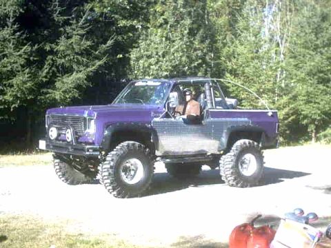 1976 Chevrolet C/K Pickup - This modified off-road vehicle features a roll cage and prominent off-road tires.
