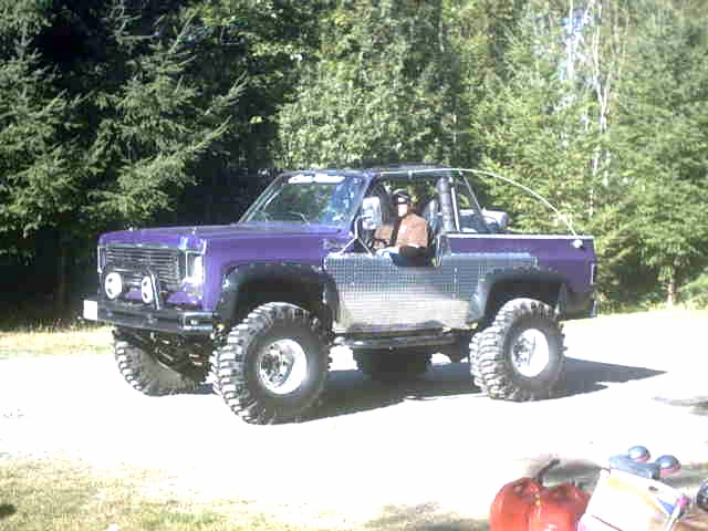 Purple off-road vehicle with chrome side panels and large tires, seen from a 3/4 front angle