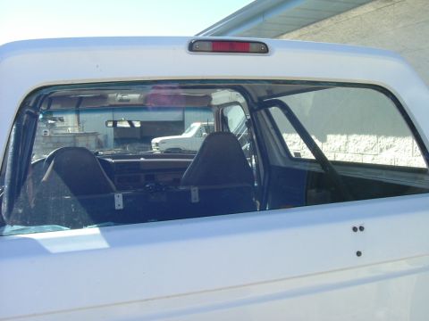 1993 Ford Bronco - View of the interior of a 1993 Ford Bronco, with a reflection of another vehicle in the rear window.