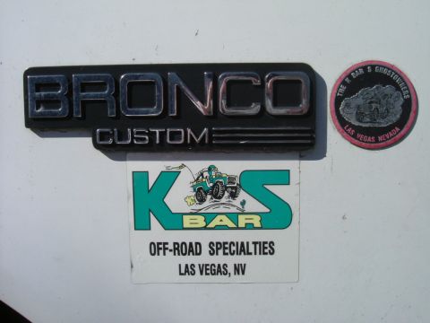 1993 Ford Bronco - Emblem and stickers on a vehicle's exterior.