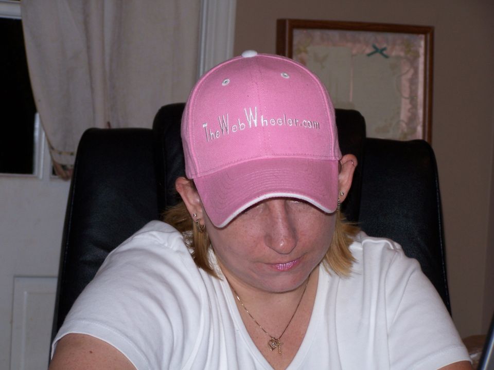 Pink baseball cap with "The Web Wheeler.com" embroidered on it