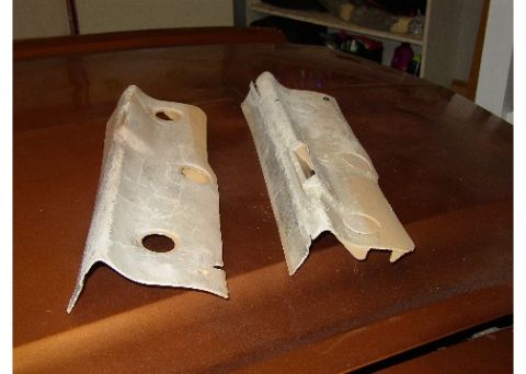 1978 Ford Mustang II - Two beige plastic interior trim pieces with circular cutouts are displayed on a brown surface.