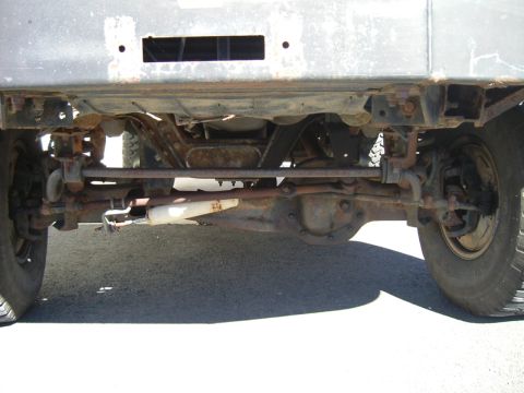 1993 Ford Bronco - Undercarriage view reveals significant rust on the rear axle and suspension components.