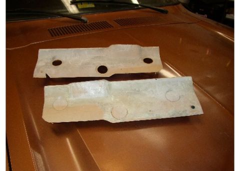 1978 Ford Mustang II - Two unpainted metal parts are shown resting on the hood of a brown vehicle.