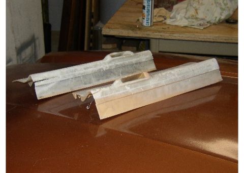 1978 Ford Mustang II - Two unfinished car trim pieces are placed on a brown car hood in a workshop.