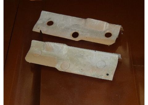 1978 Ford Mustang II - Two metal heat shields are shown against a brown background.