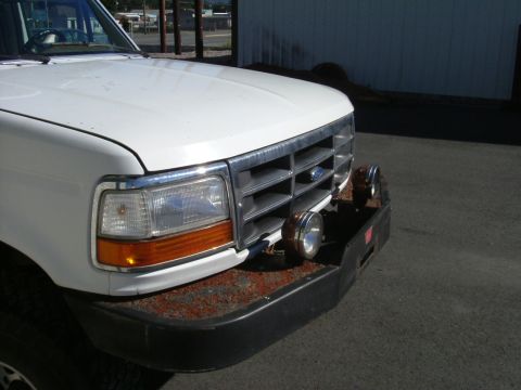 1993 Ford Bronco - Front view of a white Ford truck, showing its grille and bumper details.
