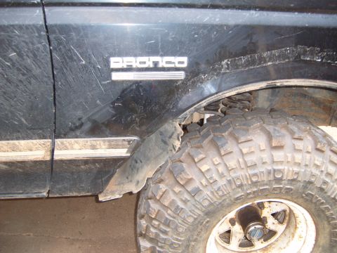 1988 Ford Bronco - Close-up of a 1988 Ford Bronco's fender trim and tire, showing off-road modifications.