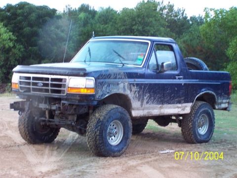 1993 Ford Bronco - This lifted Ford Bronco is covered in mud, suggesting off-road use.
