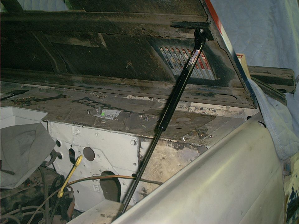 1990 Ford Bronco engine bay with hood open, showing strut and firewall