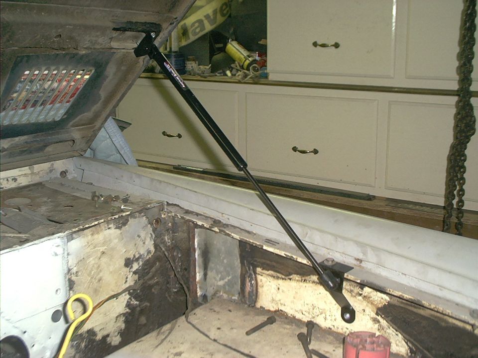 Engine bay showing open hood with a gas strut installed