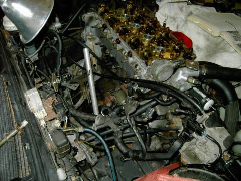 1990 Mitsubishi Eclipse - The engine's valve cover is off, exposing the camshafts and other internal parts for maintenance or repair.