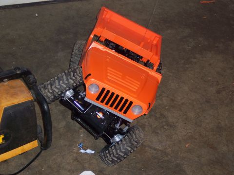 1988 Ford Bronco - An orange RC crawler truck is shown with its chassis and large tires visible.