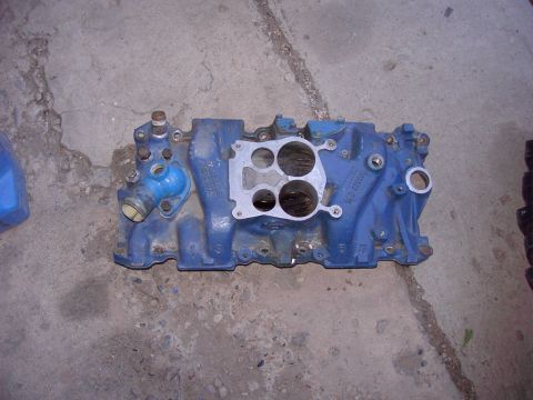 1992 Ford F-150 - A blue intake manifold with a silver gasket is shown from a top-down perspective on a concrete floor.