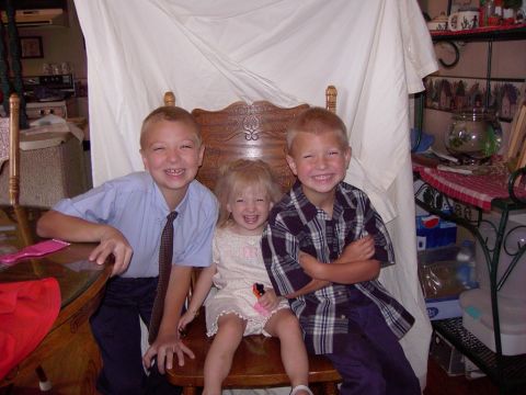 1992 Ford F-150 - Three children, two boys and a girl, are seated and smiling for a photograph taken indoors.